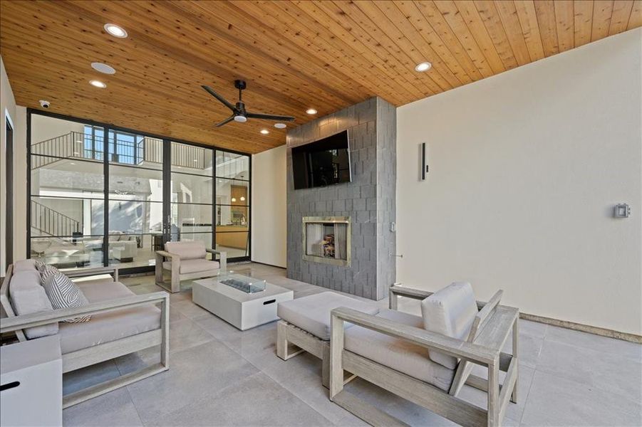 View of patio / terrace with an outdoor living space with a fireplace and a ceiling fan