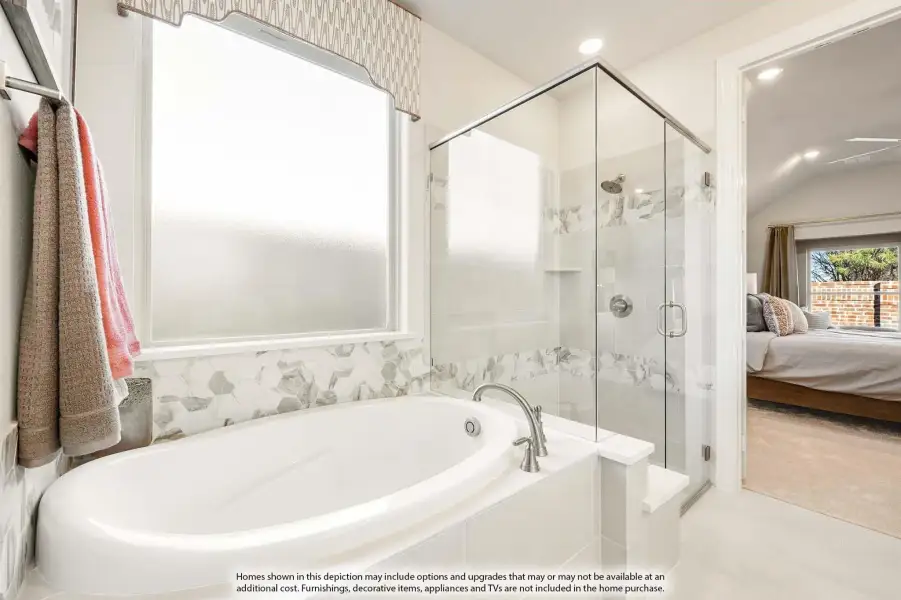 Master bathroom with soaking tub, glass-enclosed shower, and decorative tile accents