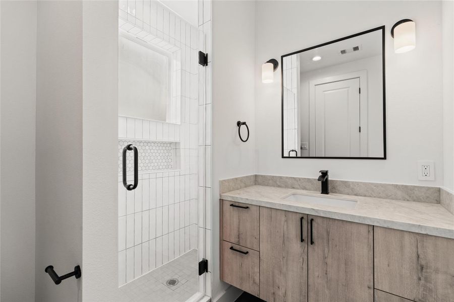 The ensuite bath features a floating vanity with ample storage and a walk-in shower with designer tile accents. The ensuite bath features a floating vanity with ample storage and a walk-in shower with designer tile accents.