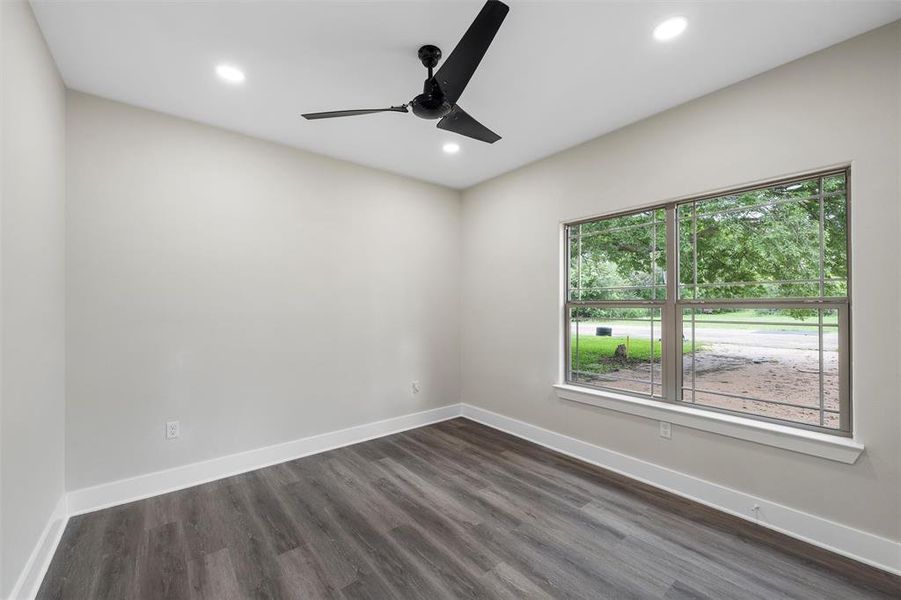Empty room featuring healthy amount of natural light, recessed lighting, a ceiling fan, dark wood-type flooring, and baseboards