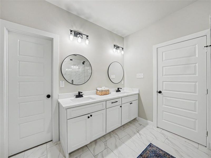 Dual vanity featuring white shaker cabinetry, white countertops, undermount sinks, and matte black hardware Dual vanity featuring white shaker cabinetry, white countertops, undermount sinks, and matte black hardware