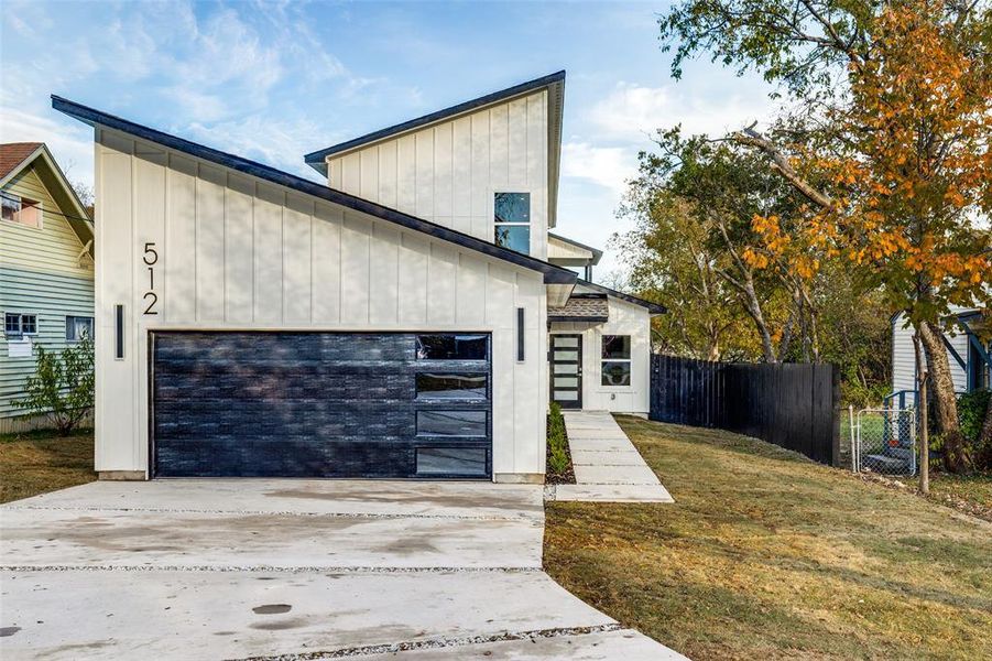 View of front of house featuring a garage and a front lawn