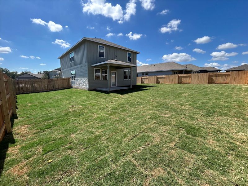 Rear view of house with a patio area, a fenced backyard, and board and batten siding Rear view of house with a patio area, a fenced backyard, and board and batten siding
