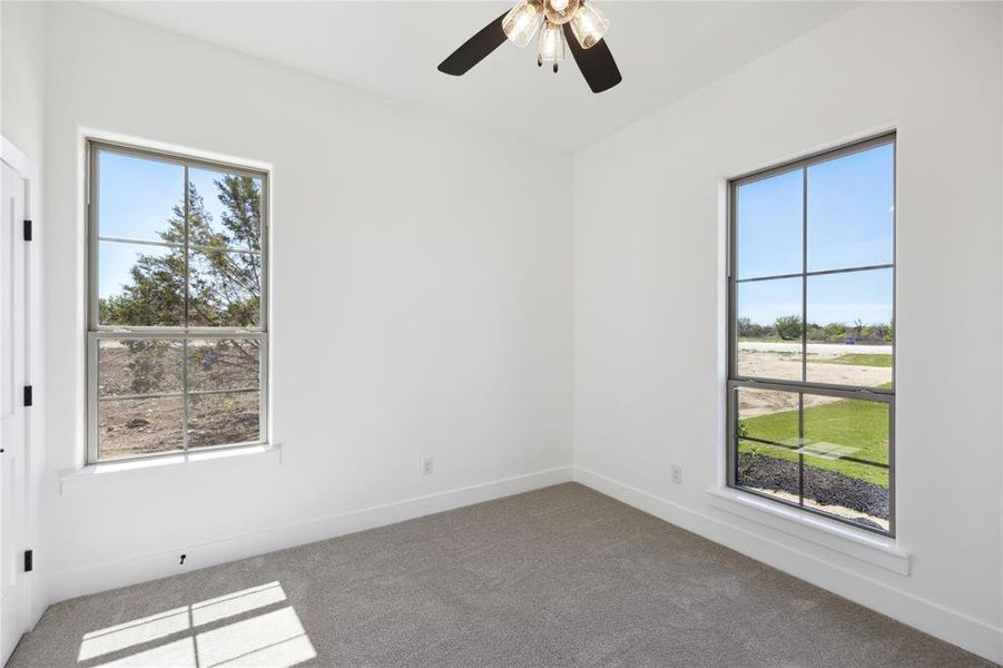 Empty room featuring carpet floors and ceiling fan