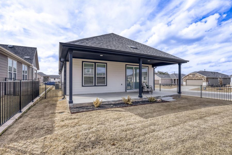 Back of house featuring a fenced backyard, a patio, roof with shingles, and a gate