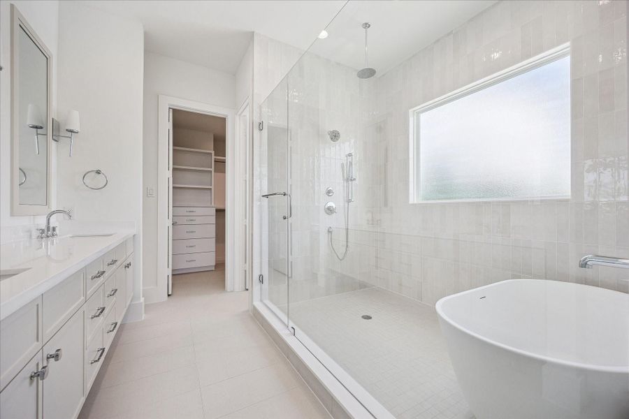 Spa-inspired primary bath with freestanding soaking tub, oversized shower and designer finishes.