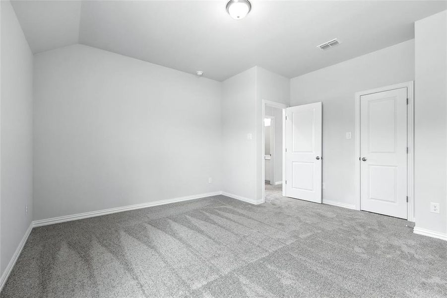 Unfurnished bedroom with carpet floors and vaulted ceiling