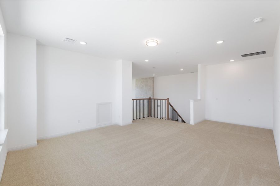 Unfurnished room with light colored carpet and recessed lighting