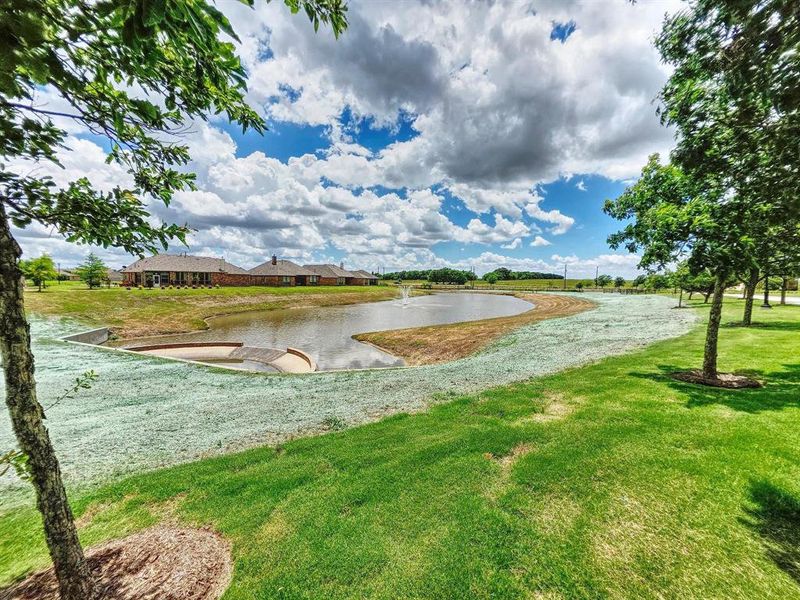 View of community featuring a water view and a yard View of community featuring a water view and a yard