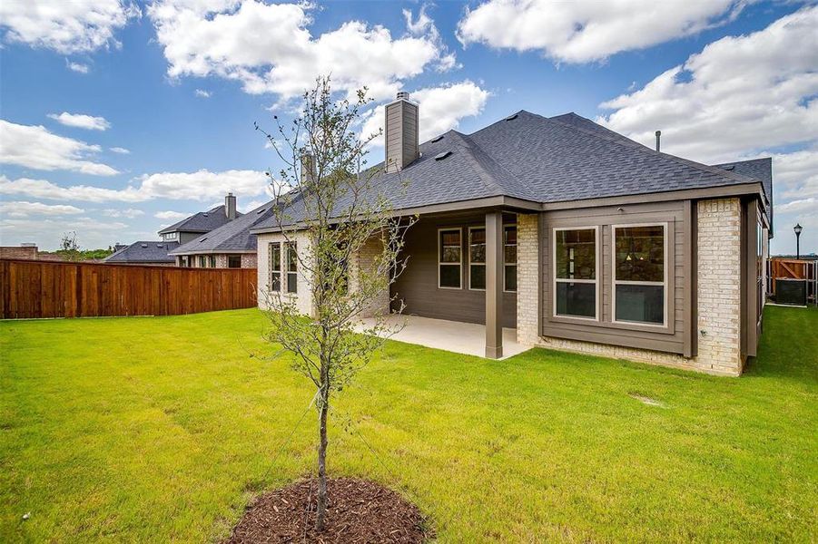 Rear view of house with a yard and a patio