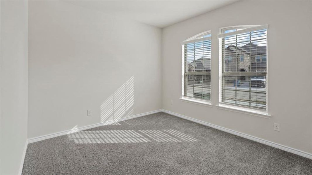 Room featuring light gray walls, gray carpeting, and white baseboards