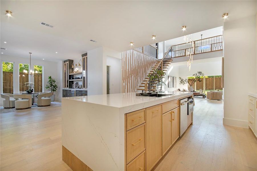 Kitchen with light brown cabinets, decorative light fixtures, light wood-type flooring, and a chandelier Kitchen with light brown cabinets, decorative light fixtures, light wood-type flooring, and a chandelier