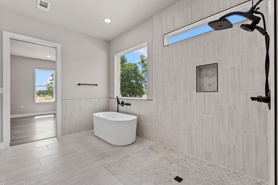 A freestanding soaking tub and an oversized shower create a peaceful spa-like environment. A freestanding soaking tub and an oversized shower create a peaceful spa-like environment.