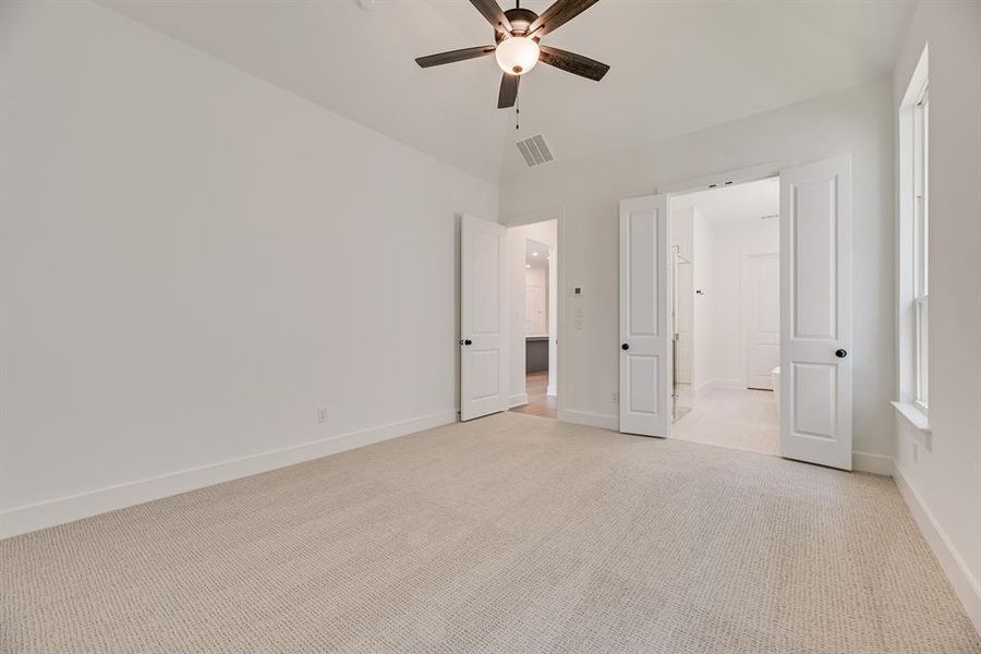 Unfurnished bedroom with light colored carpet and ceiling fan Unfurnished bedroom with light colored carpet and ceiling fan