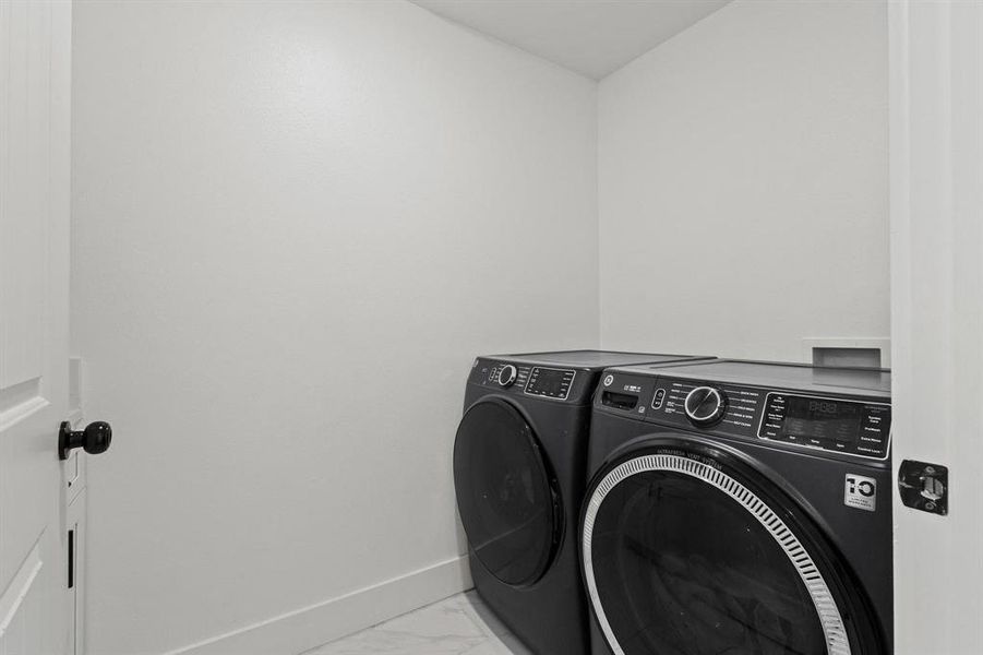 Washroom featuring independent washer and dryer and marble finish floors
