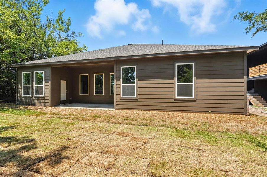 Back of house featuring a patio, a lawn, and a shingled roof Back of house featuring a patio, a lawn, and a shingled roof