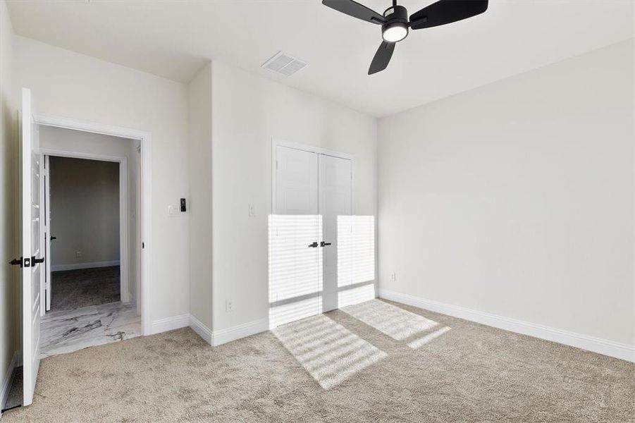 Unfurnished bedroom with carpet floors, a ceiling fan, visible vents, and baseboards Unfurnished bedroom with carpet floors, a ceiling fan, visible vents, and baseboards