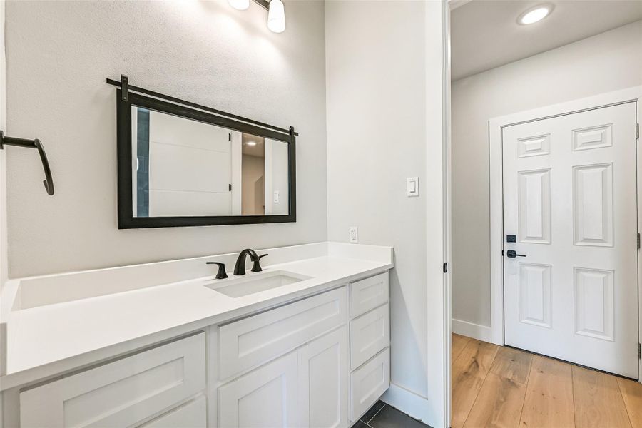 A stylish private bath featuring a sink with abundant counter space and storage. Sleek, gorgeous fixtures and thoughtful design make daily routines feel effortless and indulgent—functional luxury that enhances your lifestyle.