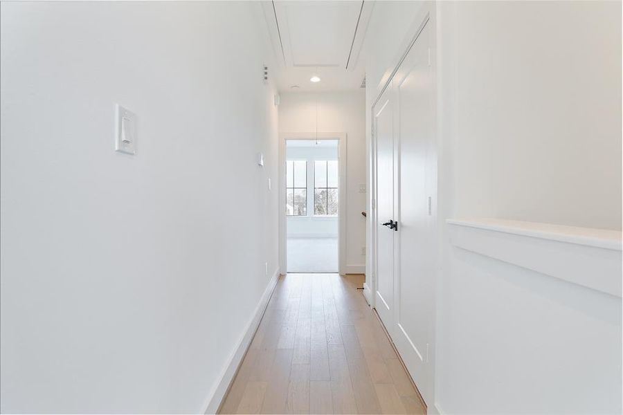 The hallway leads to a laundry room adorned with striking mosaic tile accents, adding a stylish and sophisticated touch. Located on the third floor.