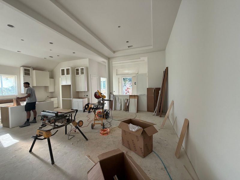 A spacious, naturally illuminated interior with high ceilings and white cabinetry awaits final touches.