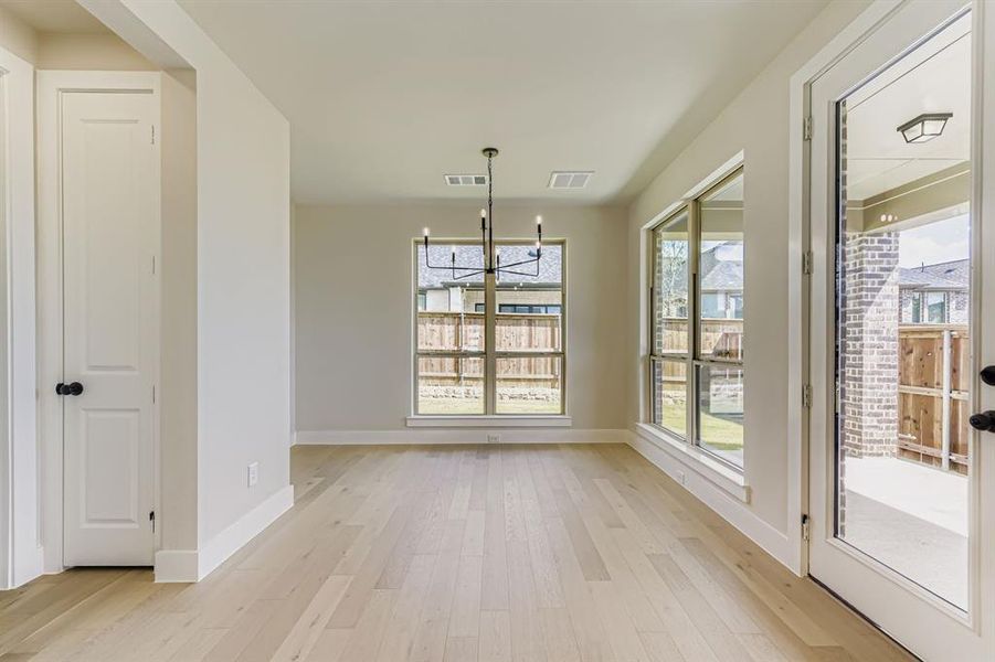 Unfurnished dining area with a chandelier and light wood finished floors
