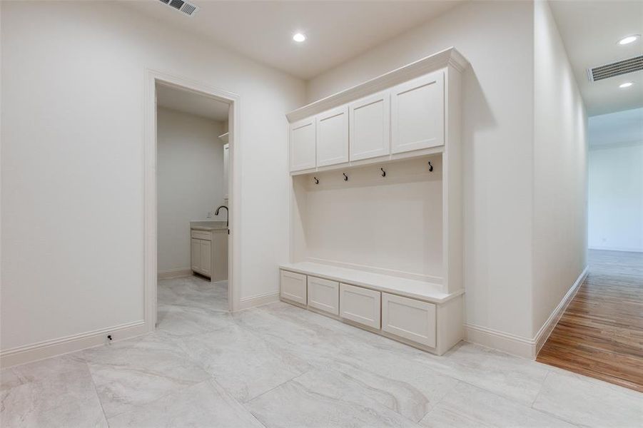 Mudroom with light wood-type flooring and sink