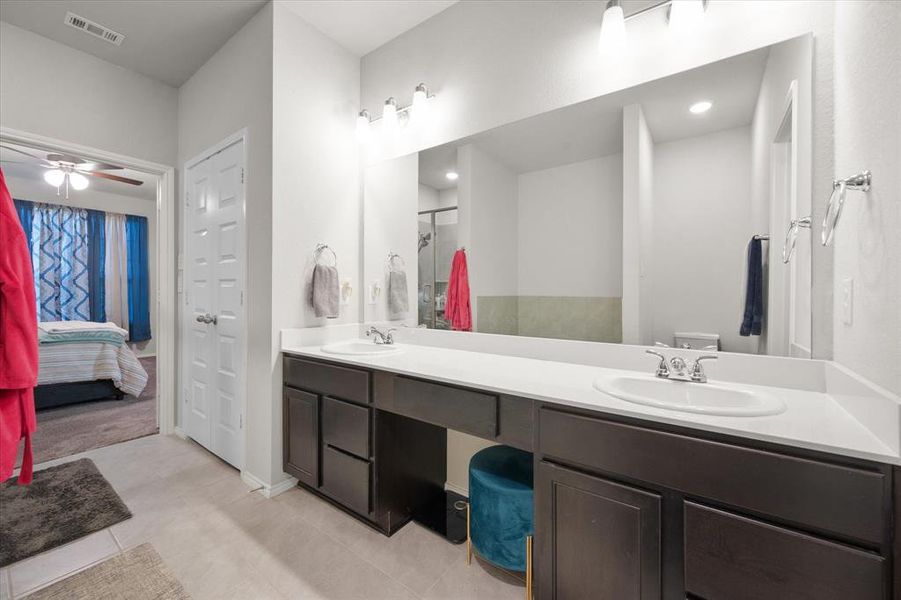 Master Bathroom with tile patterned floors, vanity, ceiling fan, a shower, and toilet