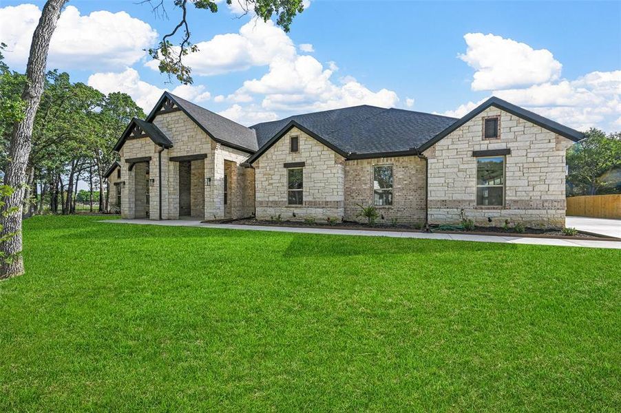 French provincial home featuring stone siding, a shingled roof, and brick siding