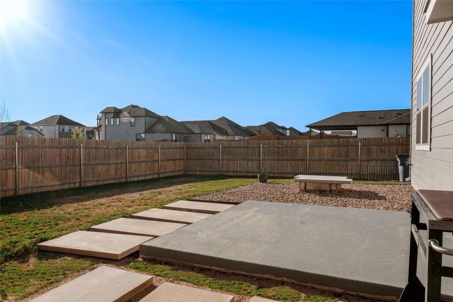 Fenced backyard featuring a residential view and a patio*some grass has been virtually staged*