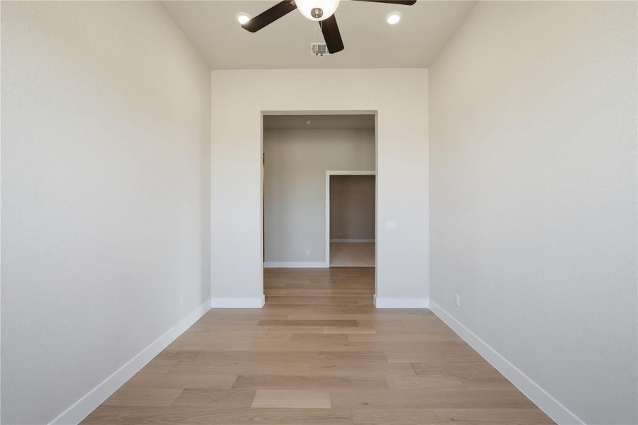 Empty room with light wood-style floors, ceiling fan, and recessed lighting