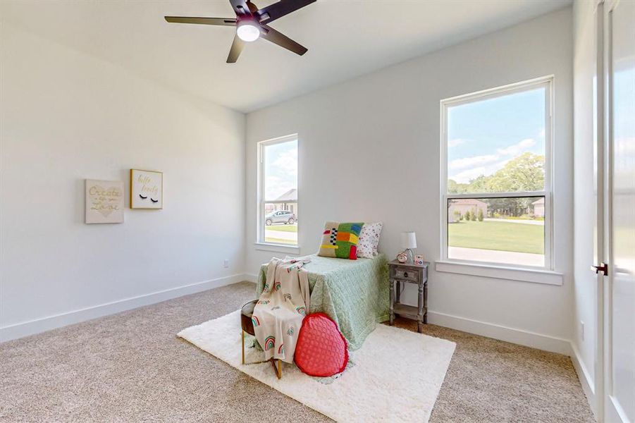 Bedroom with carpet, ceiling fan, and multiple windows