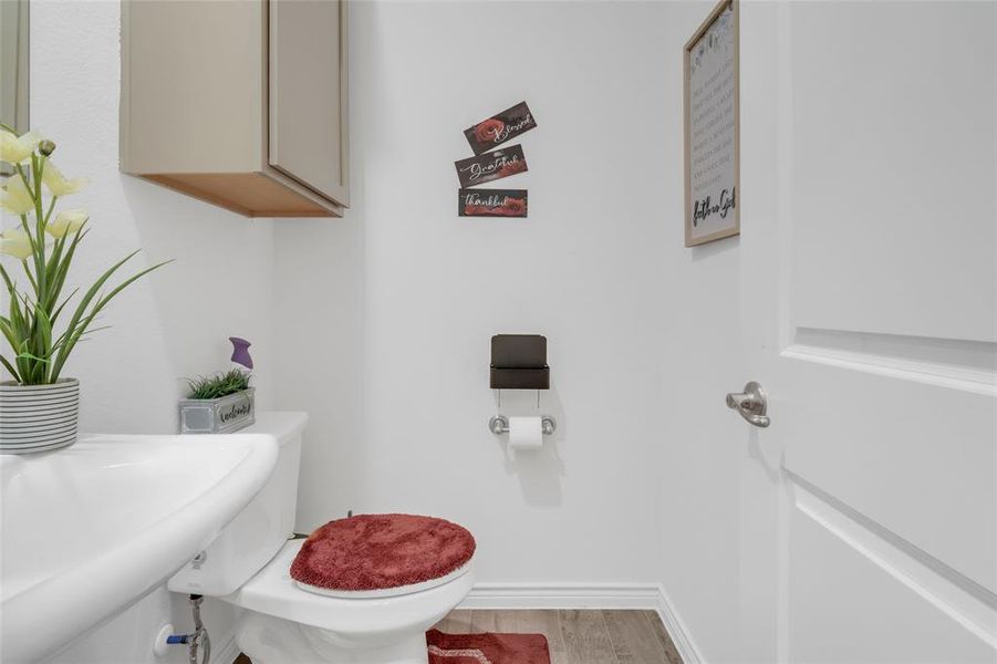 Bathroom with hardwood / wood-style floors, toilet, and sink