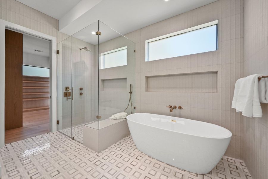 Full bath featuring a soaking tub, tile walls, and a stall shower