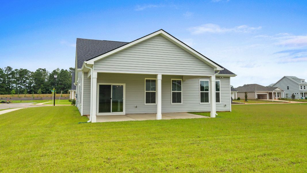 Rear view of Easton Elevation 5 at Chestnut Farms in Longs, SC, showcasing a covered back porch and spacious yard Rear view of Easton Elevation 5 at Chestnut Farms in Longs, SC, showcasing a covered back porch and spacious yard