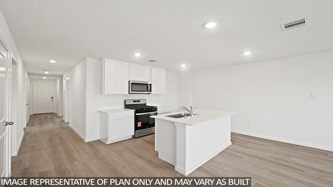 Kitchen featuring stainless steel appliances, light wood-style flooring, white cabinets, a center island with sink, and recessed lighting