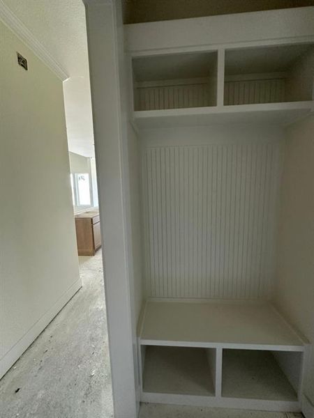 Built-in mudroom bench with beadboard backing, overhead cubbies, and lower storage compartments