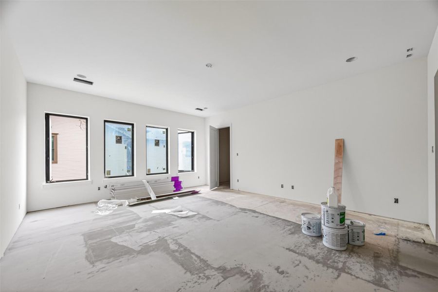 Spacious upstairs game room with dramatic high ceilings and large windows that bring in incredible natural light. Designed with an open layout and elevated finishes, it’s a versatile space ideal for a media room, play area, or secondary lounge.