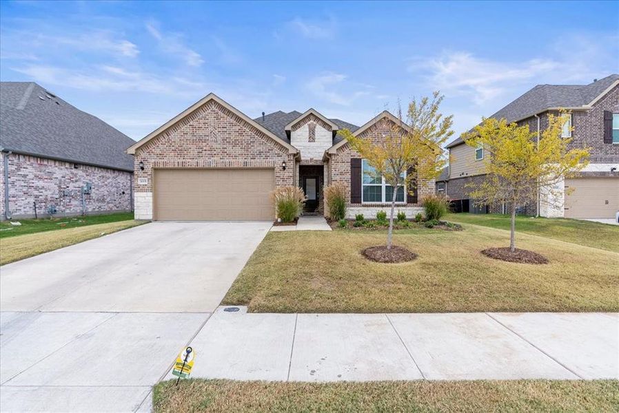 View of front of house featuring a garage and a front lawn.