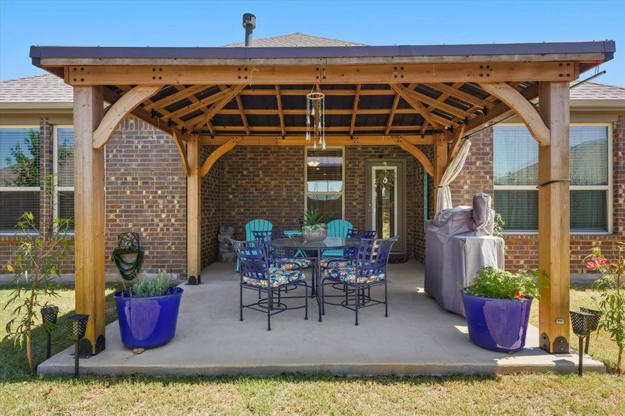 View of patio / terrace featuring a gazebo and outdoor dining area View of patio / terrace featuring a gazebo and outdoor dining area