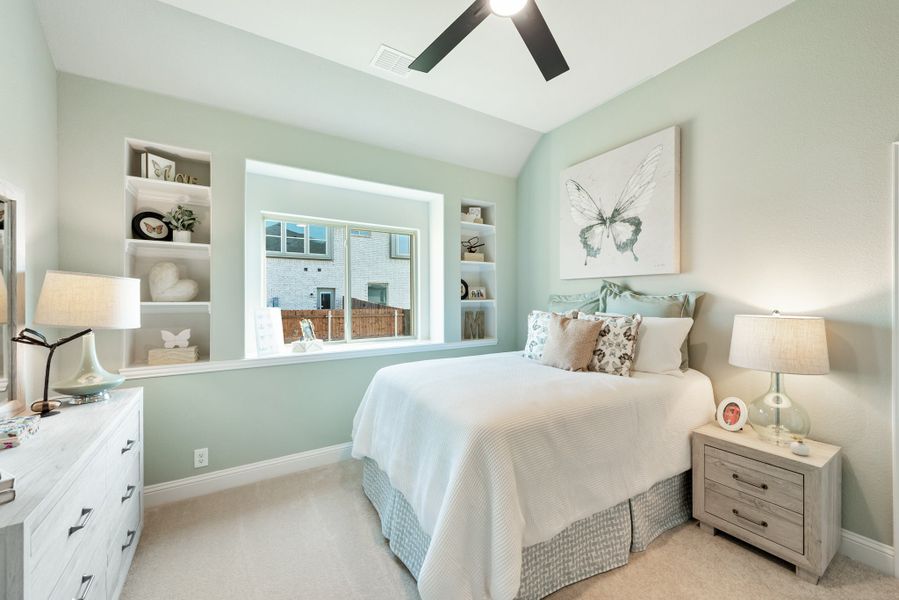 Bedroom with light green walls, built-in shelves, ceiling fan, and a large window