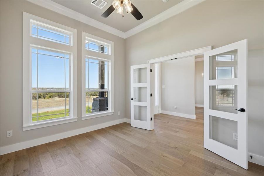 Unfurnished room featuring light hardwood / wood-style floors, ceiling fan, french doors, and ornamental molding