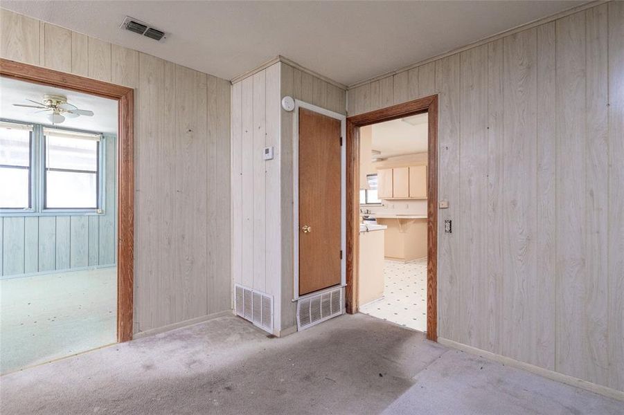 Unfurnished bedroom featuring wood walls