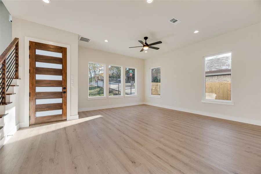 Unfurnished living room with light wood-type flooring, recessed lighting, and a ceiling fan Unfurnished living room with light wood-type flooring, recessed lighting, and a ceiling fan