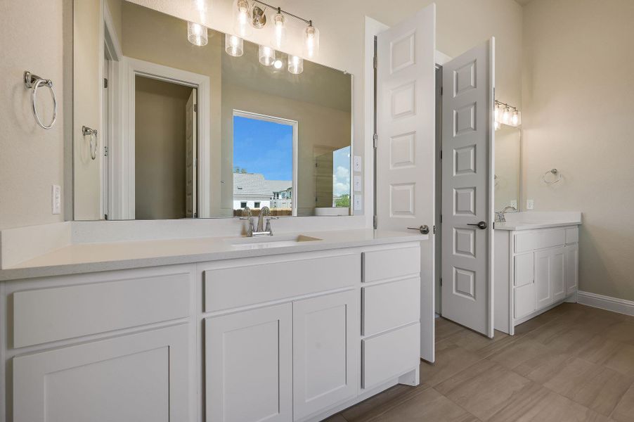 Bathroom featuring two vanities and baseboards