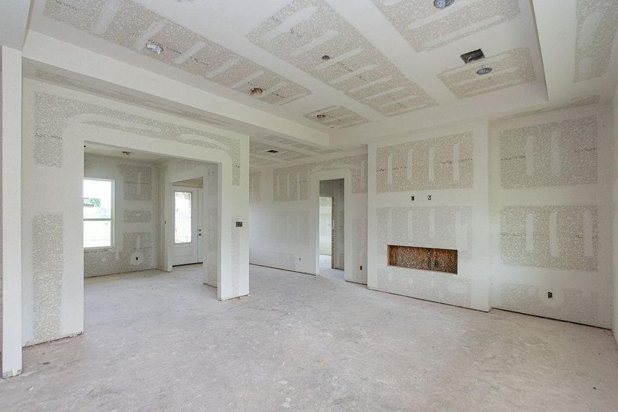 Spacious unfinished family room with large windows, electric fireplace with ample natural light, and recessed ceiling details, offering a blank canvas for customization. Spacious unfinished family room with large windows, electric fireplace with ample natural light, and recessed ceiling details, offering a blank canvas for customization.