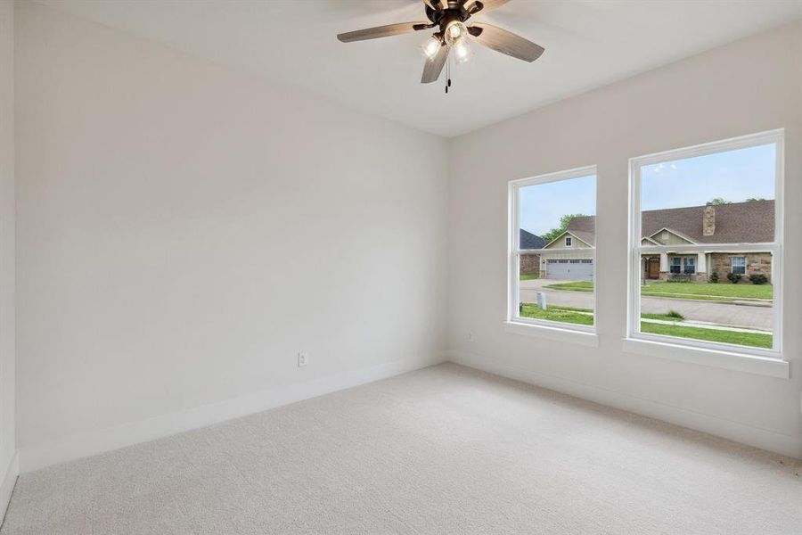 Spare room with baseboards, ceiling fan, and light colored carpet