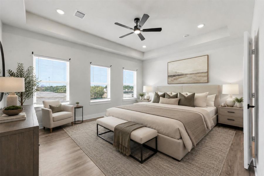 This virtually staged primary bedroom boasts a bright and spacious ambiance with a tray ceiling, wide-plank flooring, a modern ceiling fan, and large windows that flood the space with natural light. This virtually staged primary bedroom boasts a bright and spacious ambiance with a tray ceiling, wide-plank flooring, a modern ceiling fan, and large windows that flood the space with natural light.
