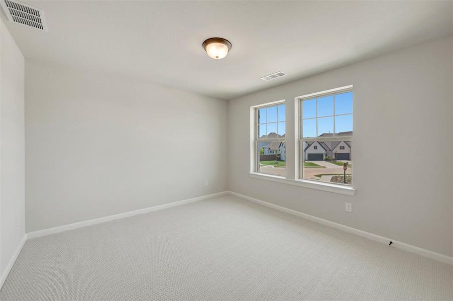 Room featuring neutral-toned carpeting, light gray wall paint, and two large windows with white trim