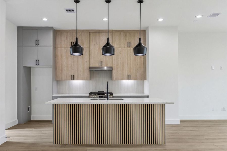 Statement island anchoring the kitchen with sleek cabinetry and designer lighting Statement island anchoring the kitchen with sleek cabinetry and designer lighting