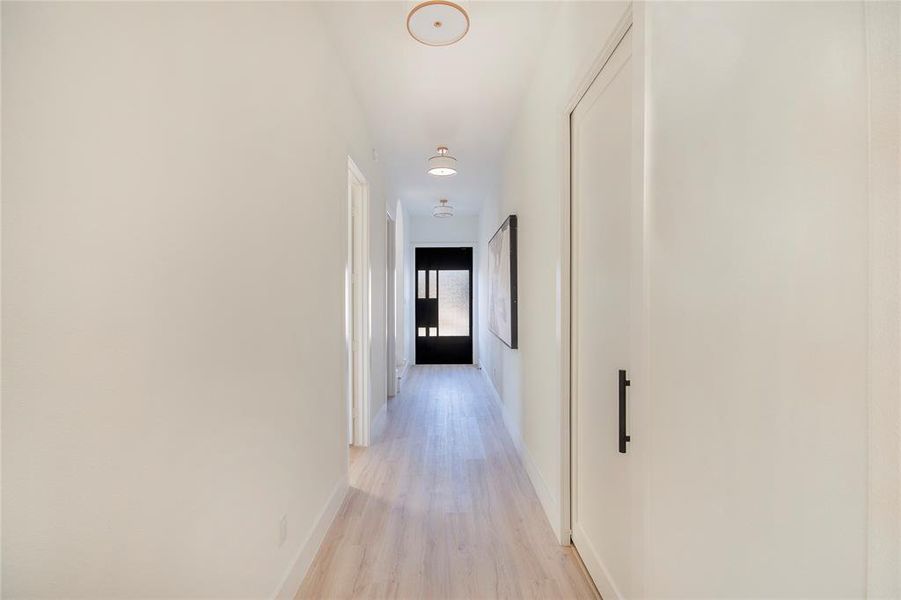 Hallway with light wood-type flooring and baseboards Hallway with light wood-type flooring and baseboards